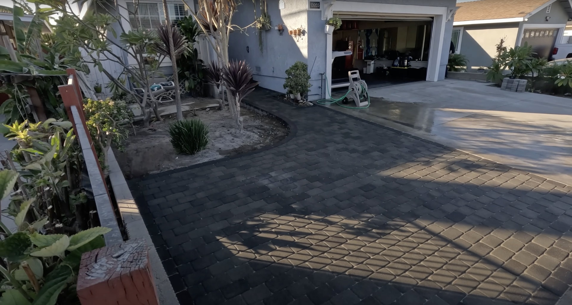 Stamped concrete driveway with decorative pattern and professional landscaping