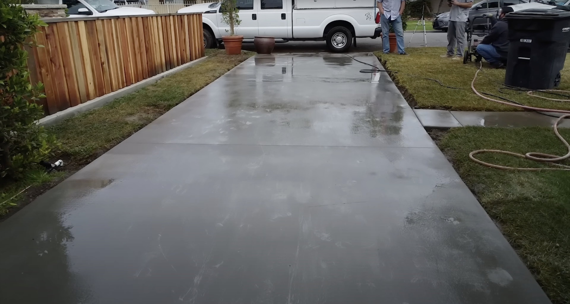 Fresh concrete driveway installation in progress with professional crew and equipment